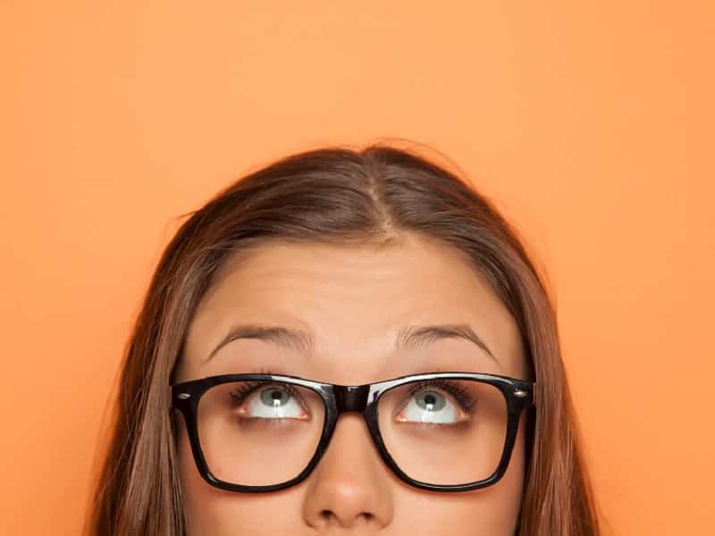 woman in glasses looking up